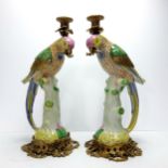 An impressive pair of large gilt metal mounted porcelain parrot candlesticks, each modelled as a