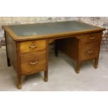 An early 20th century oak tooled leather inlaid knee-hole desk c.1940