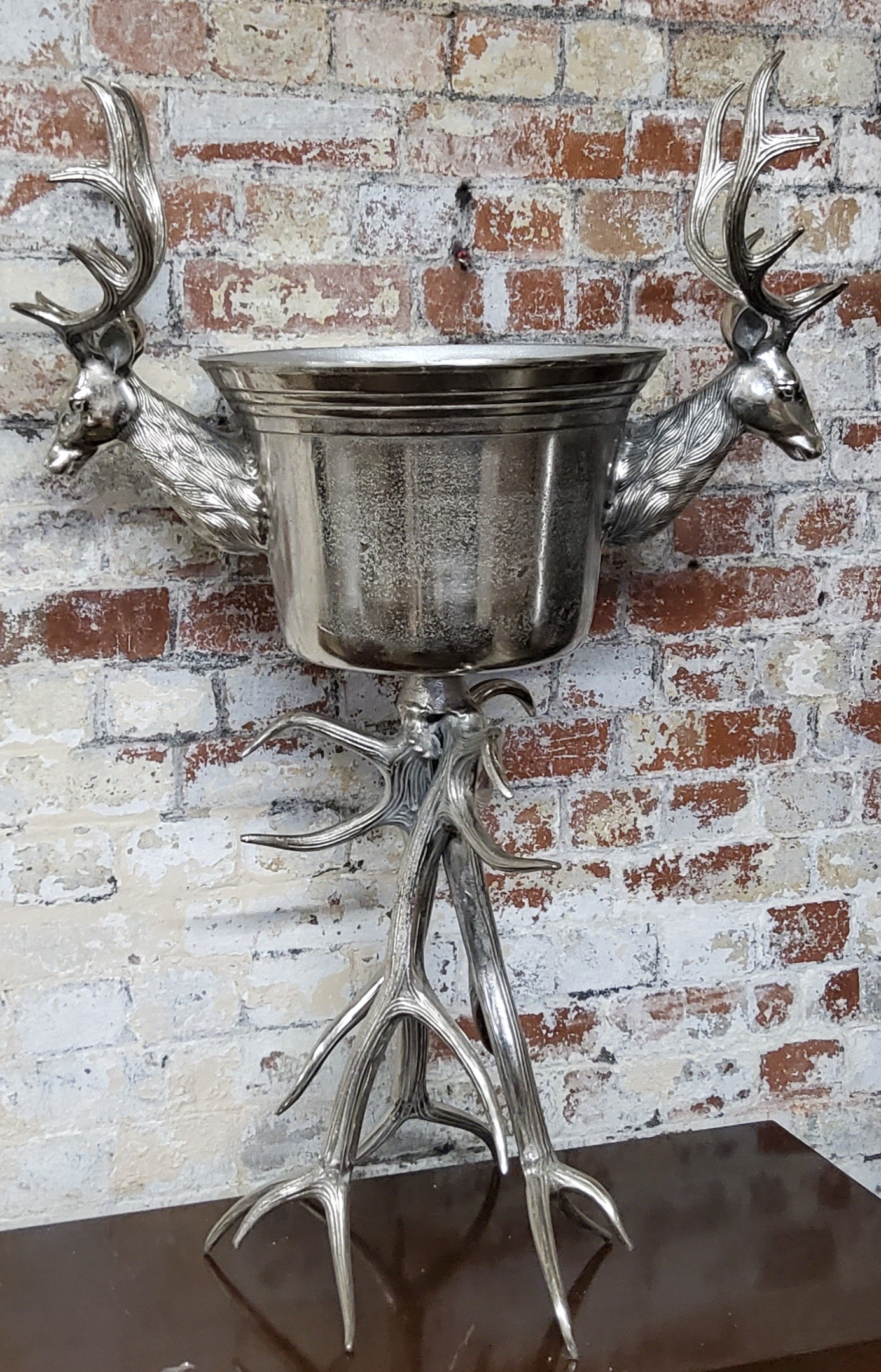 An impressive chromed champagne bucket flanked my stag heads and mounted on a stag antlers 41cms