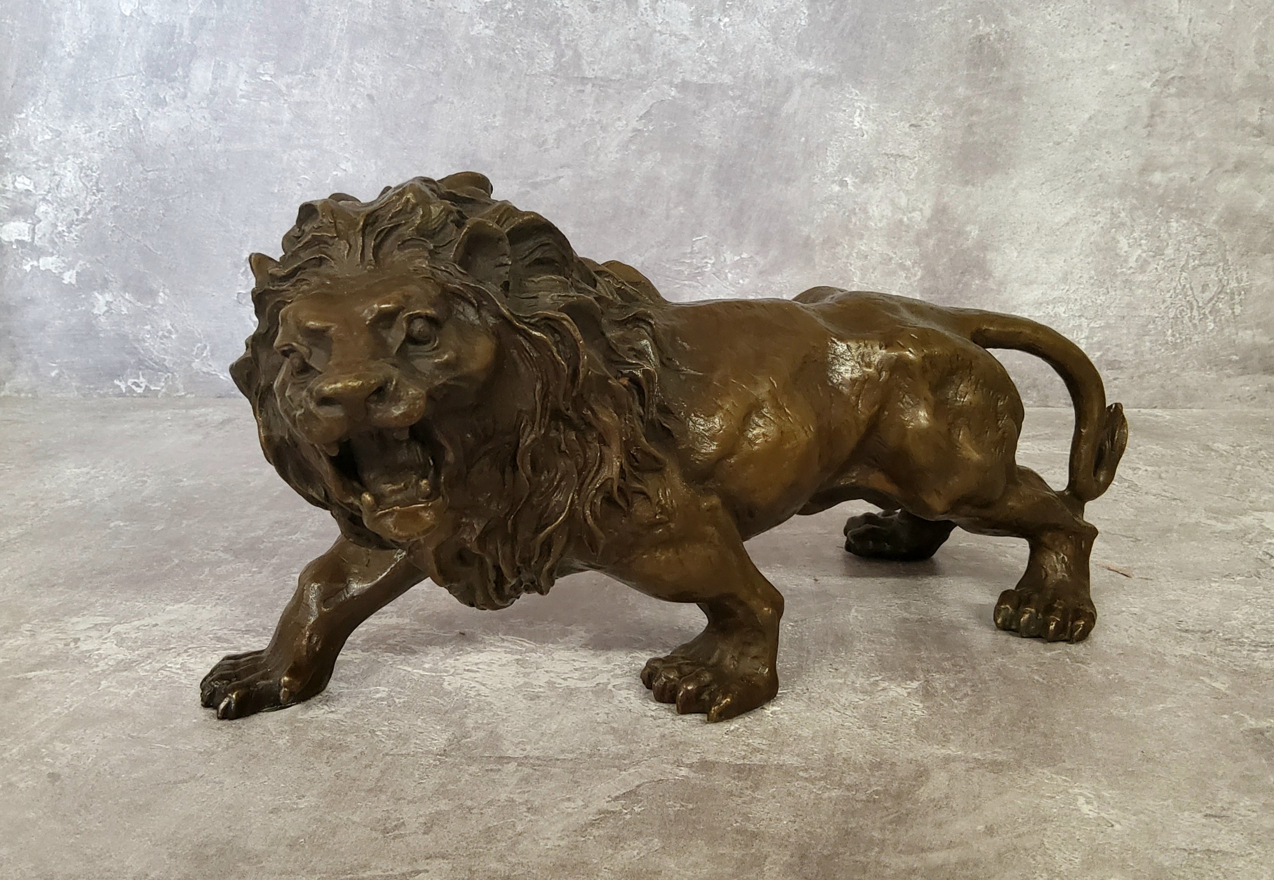 A bronze library model of a ferocious lion, bearing the signature, Rodin 31cm in length