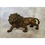 A bronze library model of a ferocious lion, bearing the signature, Rodin 31cm in length