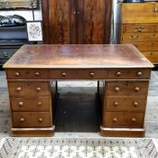 An early 20th century oak partners desk, tooled leather writing surface with keys