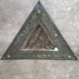 An unusual Arts and Crafts movement lead looking glass of triangular form, hand beaten geometric