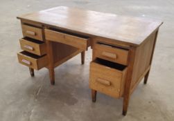 An early/mid 20th century knee-hole desk, the bowed central drawer flanked to the left with three