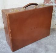 A leather gentleman's suitcase silk lined with fittings monogrammed U.F.M. with original outer