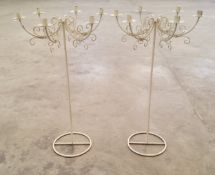 A pair of tall wrought metal freestanding six branch candle sticks