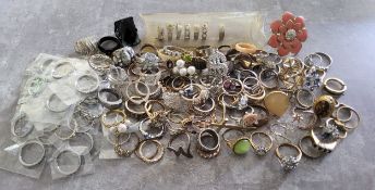 A quantity of silver & goldplated costume rings, including some set with white & coloured stones,