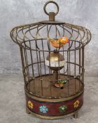 A brass novelty automaton table clock, as a bird in a cage, central posted globular dial with Arabic