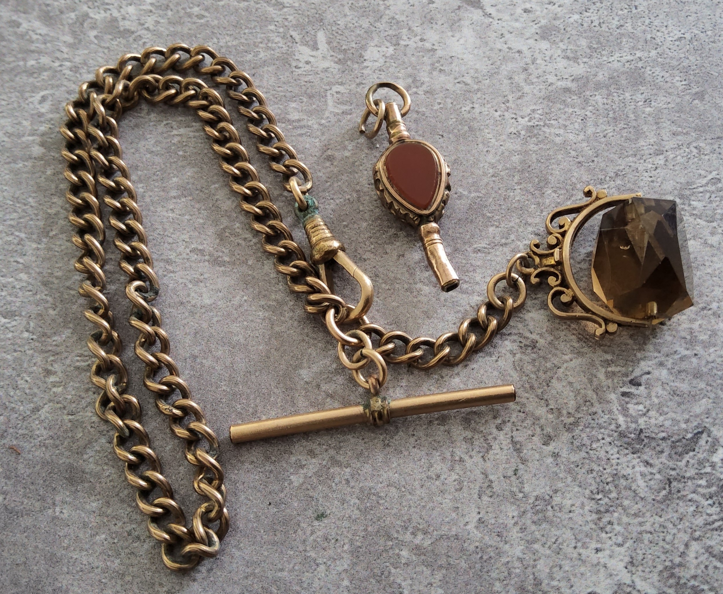 A 9ct gold fob mounted with a spinning smokey topaz on a rolled gold Albert chain with T-bar; a gilt