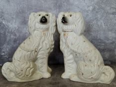 A pair of substantial Staffordshire mantel spaniels in the white, picked out in gilt 37cm high