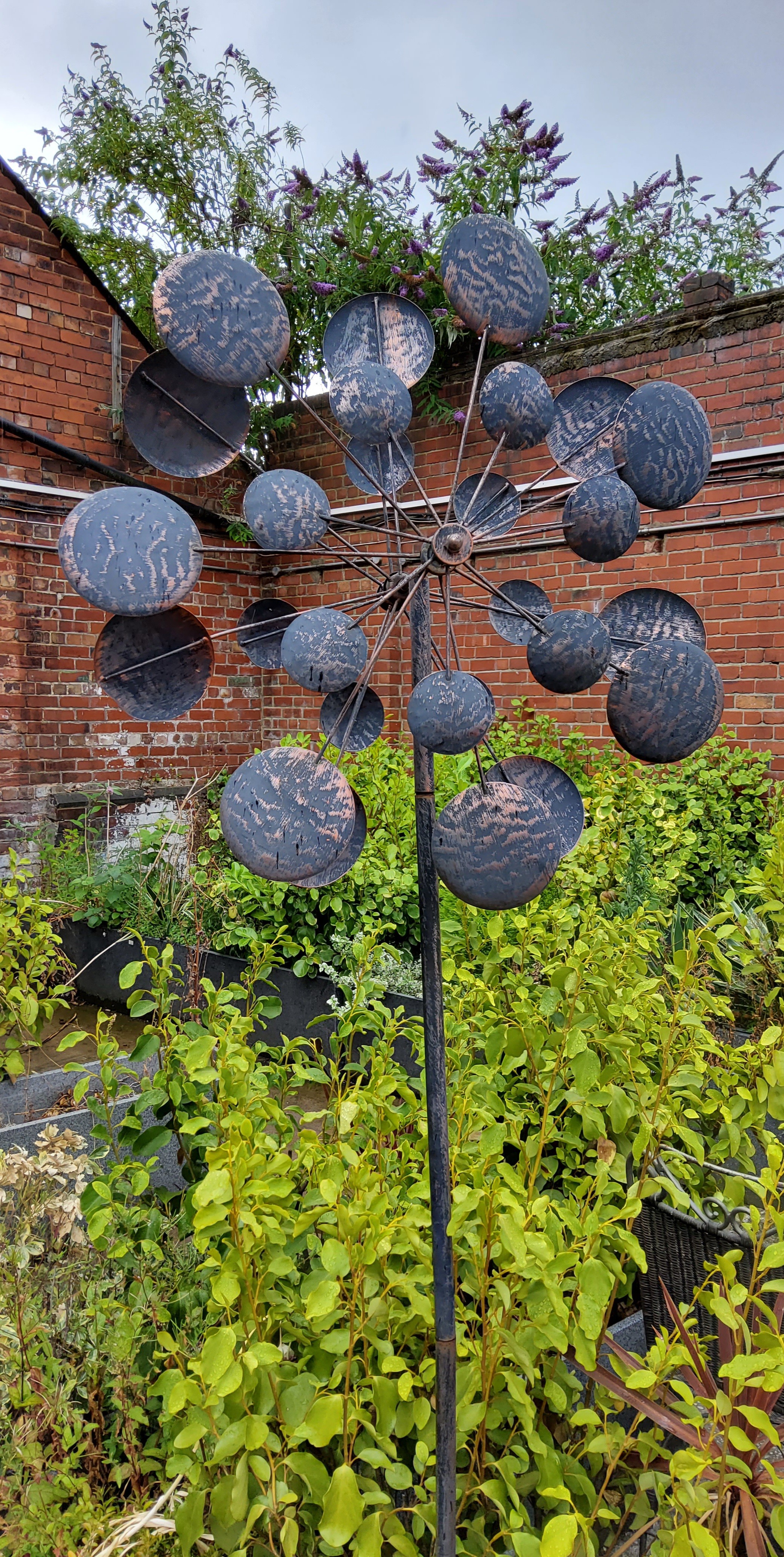 A substantial copper effect metal garden sculpture, the rotating branches decorated with stylish cup