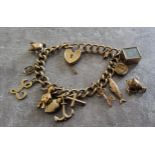 A 9ct gold charm bracelet, engraved heart shaped padlock, nine charms, one loose 29.44g