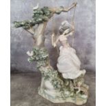 Lladro - a large figure of a woman swinging on a swing from  a tree with a King Charles Spaniel