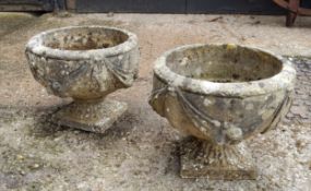 A pair of squat cast concrete planters / urns with bows and fruits pattern. 34cm h x 37.5cm in dia