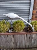 A large lead water feature statue of a feeding heron, 60 cm heigh x 100 cm long x 20 cm wide.
