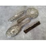 A silver backed dressing table set decorated in relief with scrolls and the Green Man, vacant