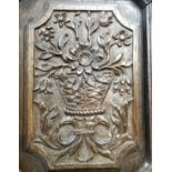 An 18th century English oak carved panel of a sunflower, flora and fauna bouquet supported by