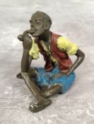 A Bergman style cold painted bronze of a young African man smoking a pipe, stamped GESCHUTZT 8127 to