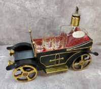 A novelty musical liqueur bar accessory in the form of a vintage car, carrying a decanter & glasses