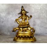 A Chinese gilt-bronze shrine deity of Guanyin, the bodhisattva shown seated in a variation of