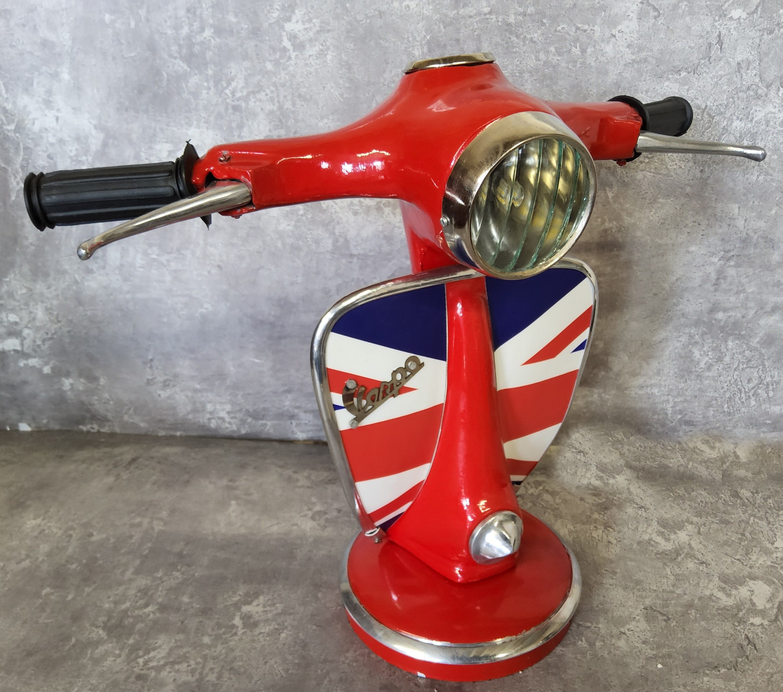 A good novelty table lamp in the form of a Vespa, red with the leg shield decorated with the Union