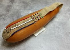 A Maasai tribe gourd drinking vessel mounted with hide and beadwork details, for drinking the