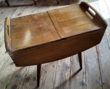 A mid 20th century 'G-plan' style sewing box the upper two hinged covers enclosing a fitted interior