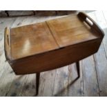 A mid 20th century 'G-plan' style sewing box the upper two hinged covers enclosing a fitted interior