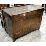 An 18th century vernacular oak Welsh coffer, the cover with early wooden hinges, brass lock above