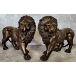 A pair of bronze lions 33cms x 24cms high