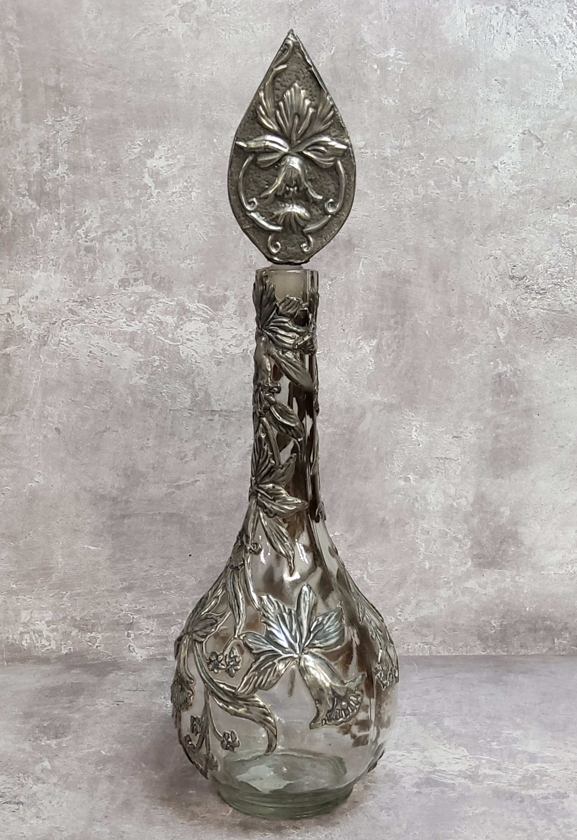A period Art Nouveau globe and stem shaft vase decorated with sinuous pewter applied reliefwork