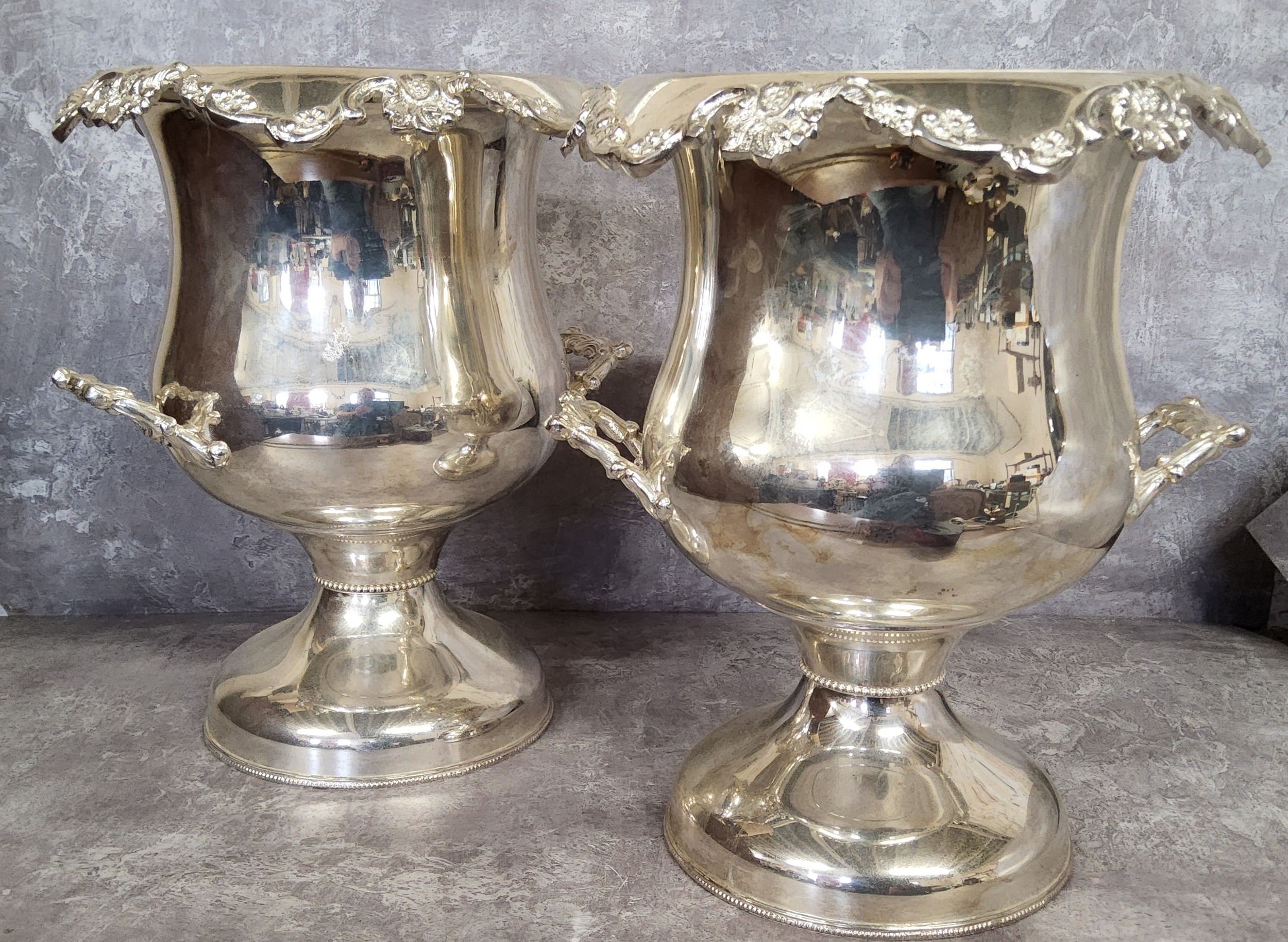 A pair silver plated two handled campana shaped champagne coolers 32cms high