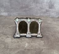 A silver Art Nouveau double picture frame, stamped sterling