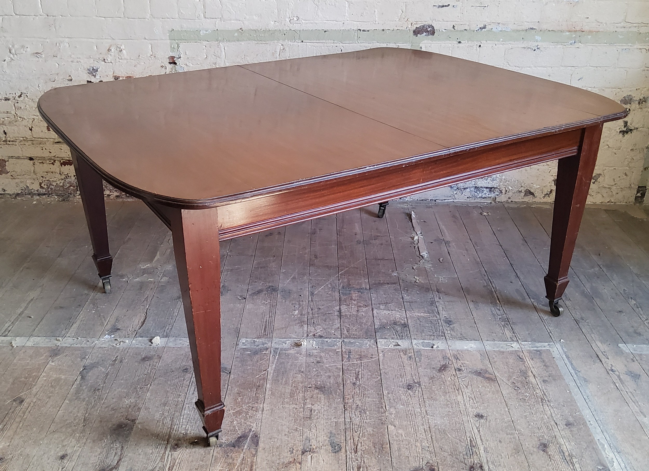 A Victorian mahogany wind-out table on brass castors c.1880, one additional leaf
