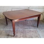 A Victorian mahogany wind-out table on brass castors c.1880, one additional leaf