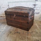 An early 20th century metal bound faux crocodile skin domed sea chest, twin leather carrying handles
