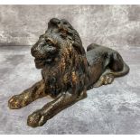 An early 20th century cast iron recumbent lion with signs of previous gold finish 12cms high x 22cms