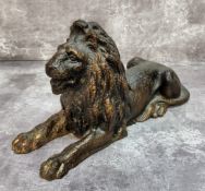 An early 20th century cast iron recumbent lion with signs of previous gold finish 12cms high x 22cms