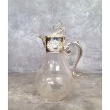 An elegant silver plate mounted claret jug, terminating with a lion and shield hinged lid with green