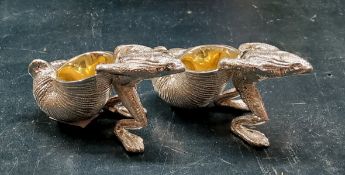 A pair of novelty cast white metal salt cellars with gilt interiors