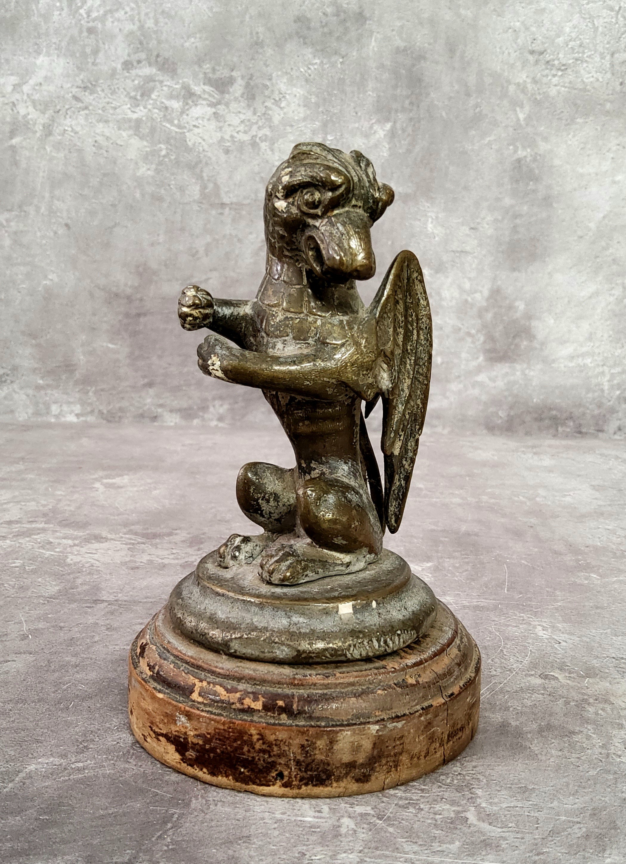 Automobilia - A bronze car mascot in the form of a seated Gryphon / griffin with folded wings