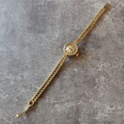 A 9ct gold lady's Omega watch, 17 jewel movement, silver dial black baton markers, integral fancy