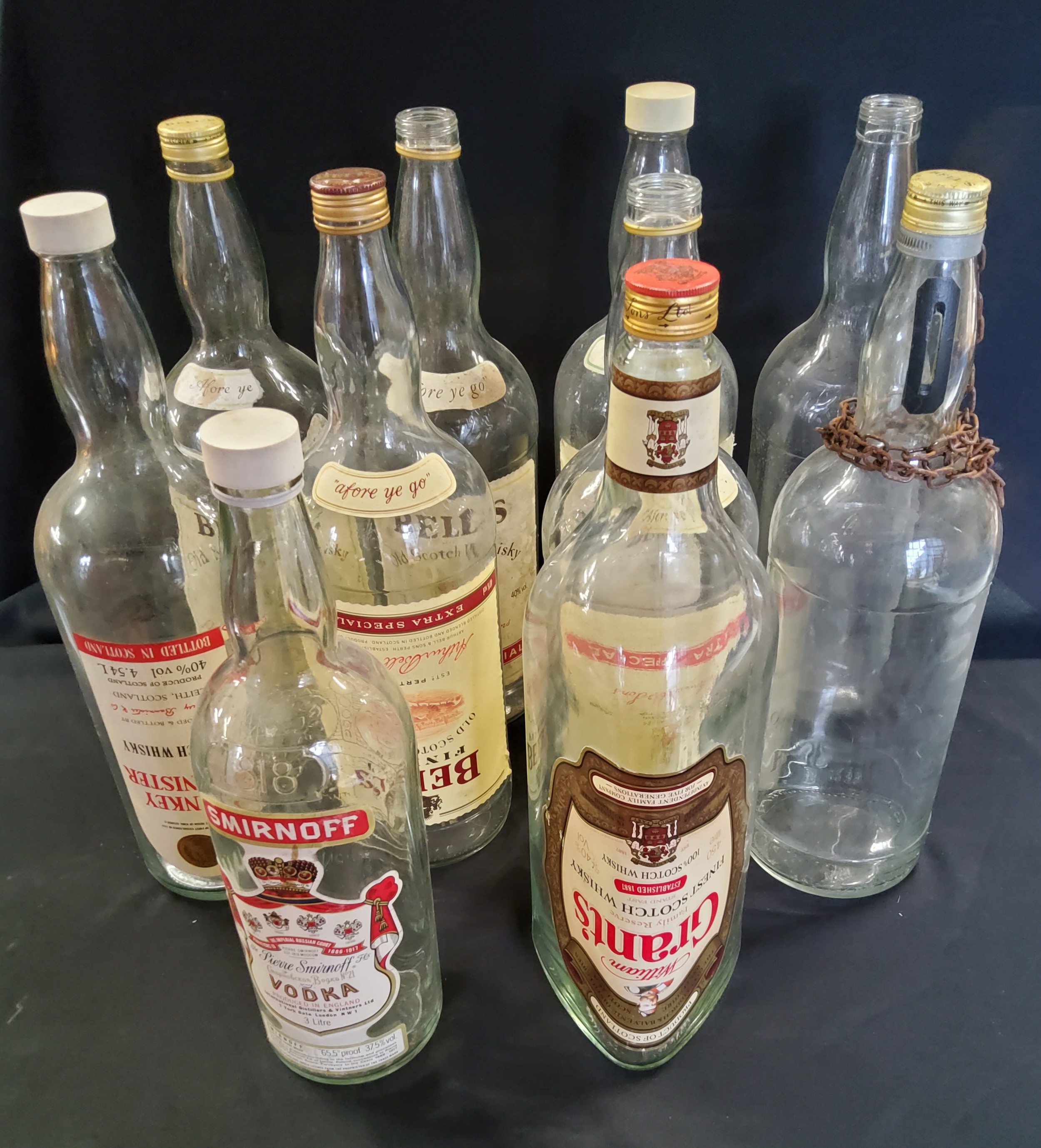 Advertisement- nine large 4.5l whisky bottles, including Bells, Grants, Hankey Bannister, one