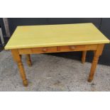 A farmhouse pine side table with two small drawers to frieze, covered in fitted yellow plastic "