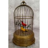 An early 20th Century birdcage automaton with decorative pressed brass base and cage containing