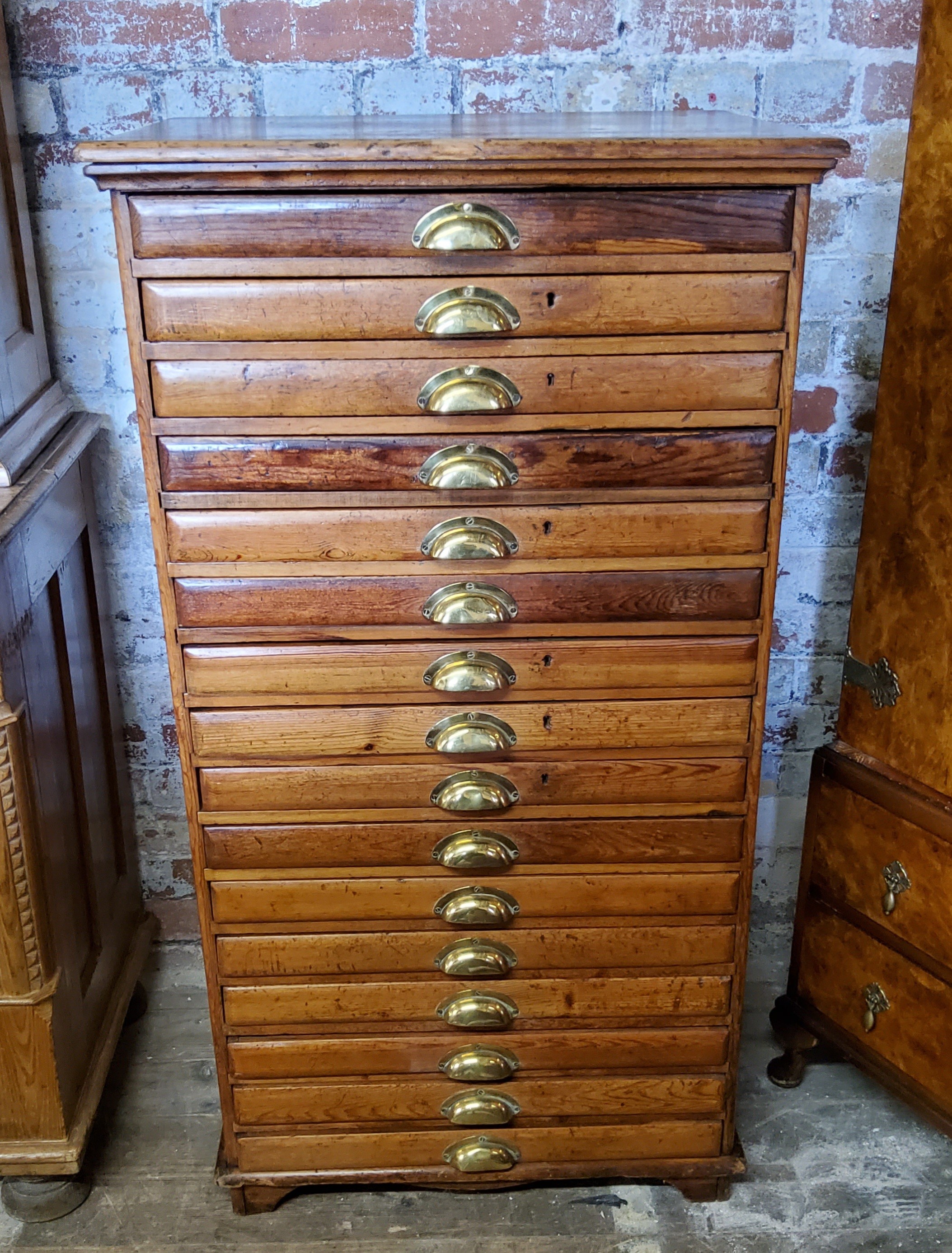 A late 19th century farmhouse pine bank of sixteen collectors drawers / printers drawers with