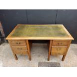 A 1940's oak knee-hole desk with green tooled leather inlaid top, five drawers. H77 x W137 x D76cm