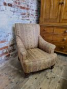 A late Victorian armchair re- upholstered in chintz striped fabric, raised on mahogany cabriole legs