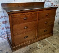 A 1920's elm and oak bank of haberdashery drawers with protective glass top Height 93.5cm x width