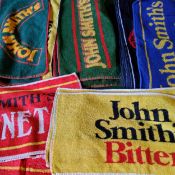 Twenty four John Smith's beer towels.